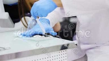 牙医在蓝色乳胶手套打开包装与牙科无菌工具，特写。